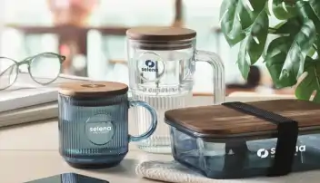 Kubki reklamowe z pokrywką drewnianą. Zdjęcie studyjne stołu z 2 kubkami i lunchboxem.